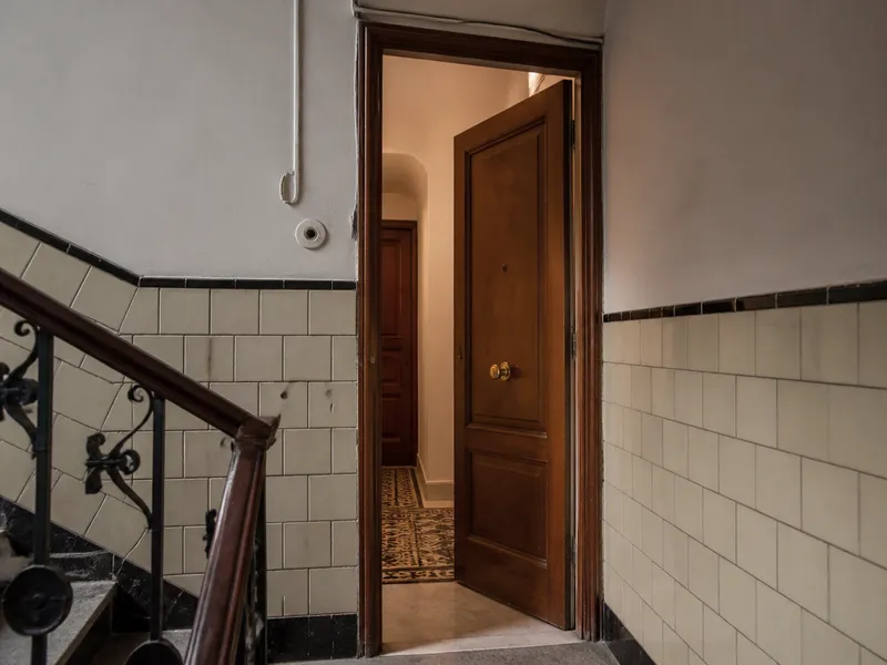 Puerta de piso abierta en un rellano de Barcelona tras un aviso de cerrajero.